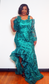 Lace evening dress with side ruffle.        Color: Hunter green